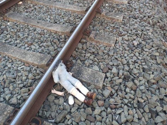 Puppe auf Gleise gelegt