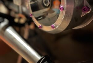 a close up of a metal object with pink flowers on it