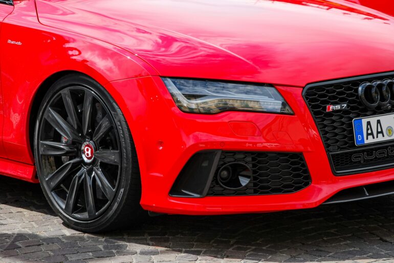 a close up of a red car parked on a street