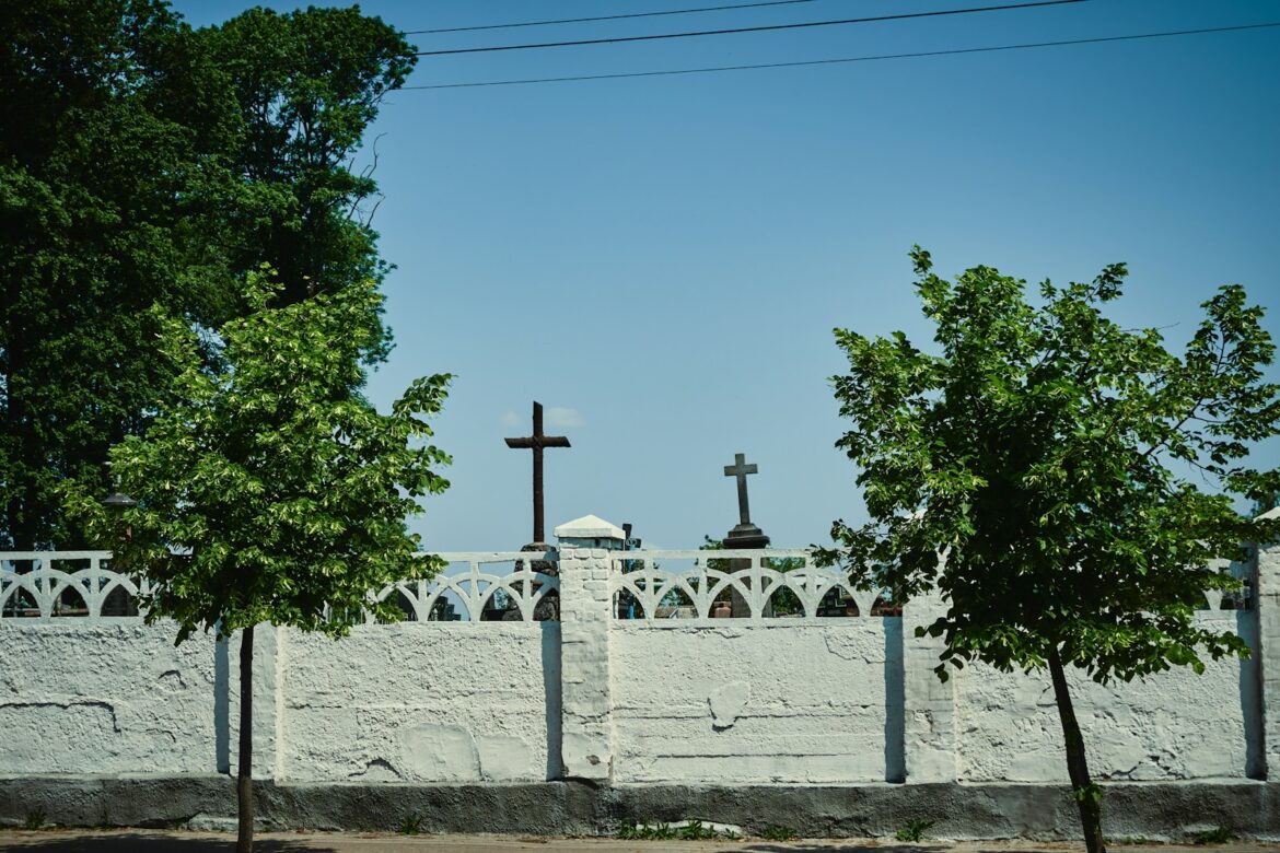 a white fence with a cross on top of it