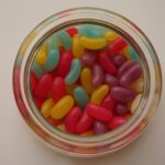 orange and red candies in clear glass jar