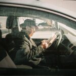 man in black jacket driving car