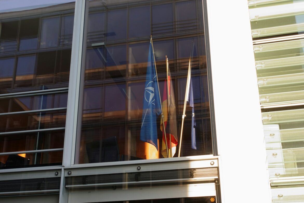 Flags are displayed in a modern building window.