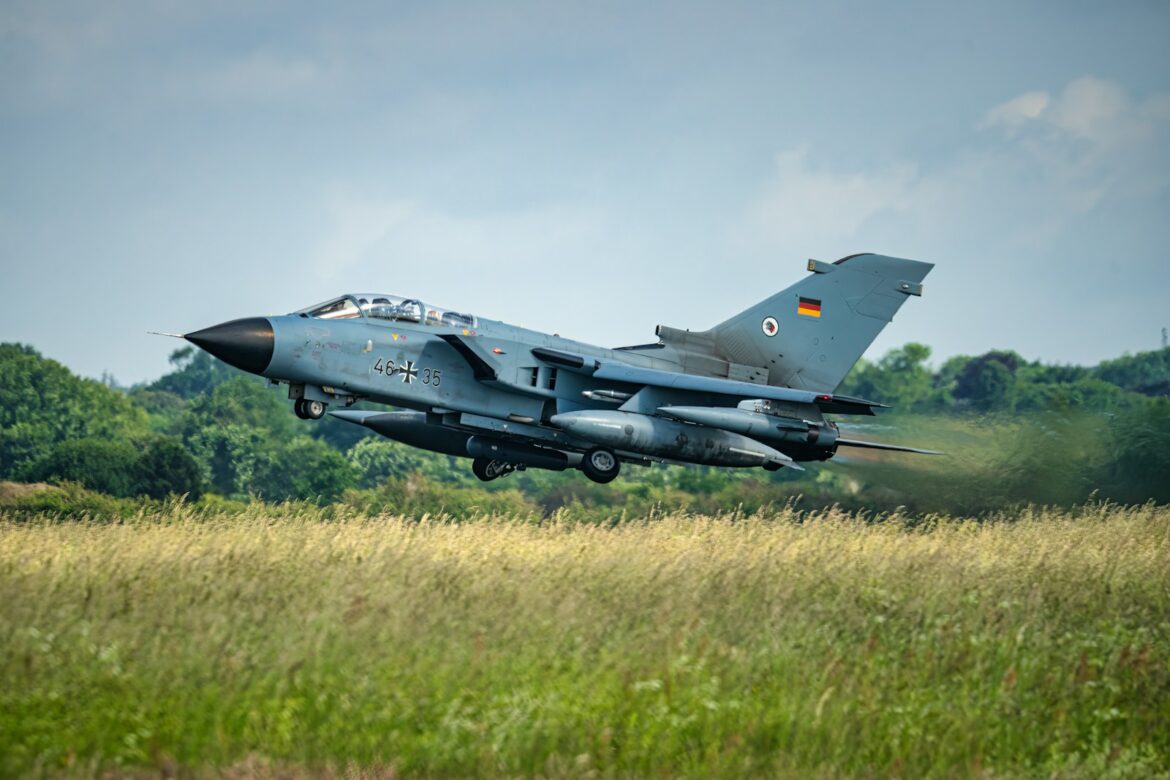 German tornado jet taking off from grassy field.