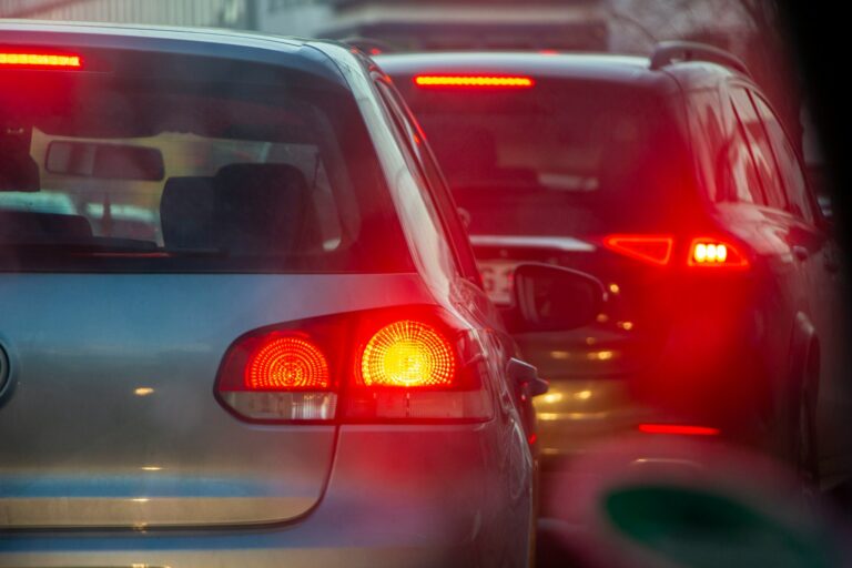 a group of cars driving down a street next to each other