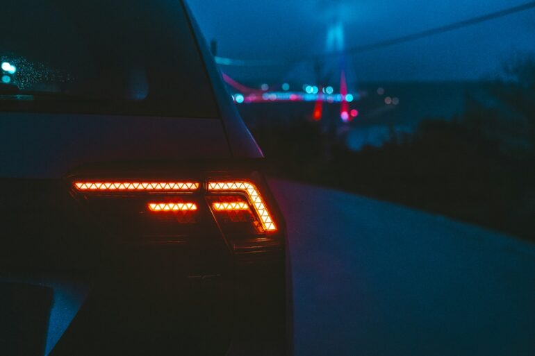 the tail lights of a car in the dark