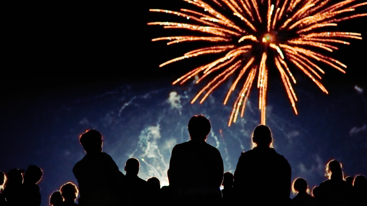 Feuerwerk am Himmel. Personen schauen nach oben.