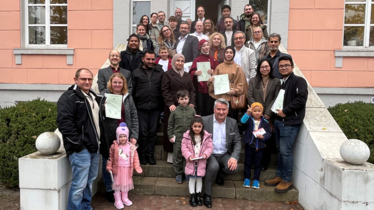 Einbürgerung Gruppe: Nach Abschluss der Feier hatte Landrat Miroslaw Kowalski die eingebürgerten Personen und ihre Angehörigen zu einem gemeinsamen Foto auf der Schlosstreppe eingeladen.
