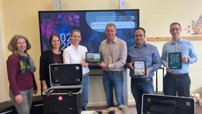 Foto: Übergabe der iPads an der Dr.-Martin-Luther-King-Grundschule (v.l.): Nina Keil, Schulamt, Kim-Kristin Weis, Konrektorin mit Schulhund Sammy im Vordergrund, Eva Steitz, Rektorin, Mirko Helmut Kohl, Schuldezernent, Gökhan Demirdag und Lennart Ludwig, beide Schul-IT Kreisverwaltung.