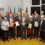 Landrat Thomas Barth (Mitte) mit den Geehrten und Vertretern der Kommunen sowie des Beirates der Stiftung „Kultur im Landkreis“ Mainz-Bingen